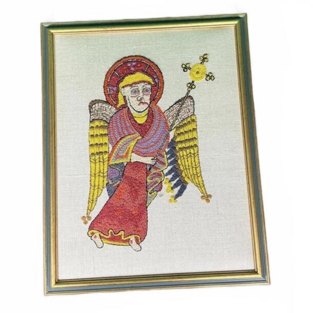 Framed vintage cross-stitch embroidery depicting the portrait of St. Matthew